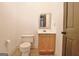 Small bathroom includes a toilet, vanity with sink, and a mirror, offering a compact design at 115 Shoal Creek Dr, Sharpsburg, GA 30277