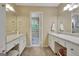 Bathroom featuring dual vanities and a connecting door to another bathroom at 115 Shoal Creek Dr, Sharpsburg, GA 30277