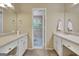 Bathroom featuring dual vanities, neutral walls, and a connecting door at 115 Shoal Creek Dr, Sharpsburg, GA 30277