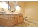 Bright bathroom showcasing a wooden vanity with sink and a toilet, exuding functional charm at 115 Shoal Creek Dr, Sharpsburg, GA 30277