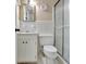 Classic white bathroom featuring a vanity, toilet, shower with a frosted glass door, and mosaic tile floor at 115 Shoal Creek Dr, Sharpsburg, GA 30277