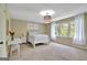 Bright, spacious bedroom with carpet, a bed, a vanity, and natural light streaming through the large windows at 115 Shoal Creek Dr, Sharpsburg, GA 30277