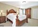 Bedroom with a decorative wood bed, a full closet, and neutral carpeting at 115 Shoal Creek Dr, Sharpsburg, GA 30277