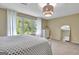 Bright bedroom with large window, white curtains, and stylish light fixture at 115 Shoal Creek Dr, Sharpsburg, GA 30277