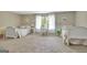 Spacious neutral bedroom with two beds, white furnishings, and neutral walls at 115 Shoal Creek Dr, Sharpsburg, GA 30277