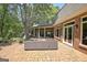 Expansive brick patio provides a relaxing outdoor space with multiple seating options and views of the lush yard at 115 Shoal Creek Dr, Sharpsburg, GA 30277