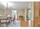Formal dining room featuring modern chandelier, six-chair table, and window view to the backyard at 115 Shoal Creek Dr, Sharpsburg, GA 30277