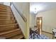 Cozy dining room features wainscoting, blue rug, and table set, adjacent to a staircase for easy access at 115 Shoal Creek Dr, Sharpsburg, GA 30277