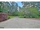 Long driveway lined with manicured landscaping and mature trees at 115 Shoal Creek Dr, Sharpsburg, GA 30277
