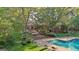 Beautiful backyard featuring a sparkling pool, brick patio, landscaped garden, and the home's exterior at 115 Shoal Creek Dr, Sharpsburg, GA 30277