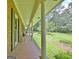 A covered front porch with stately white columns offers views of the expansive, lush front yard at 115 Shoal Creek Dr, Sharpsburg, GA 30277