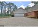 Attached garage with a multi-panel door and a long driveway at 115 Shoal Creek Dr, Sharpsburg, GA 30277