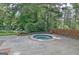 A tranquil hot tub surrounded by lush greenery and brick accents, offering a private outdoor retreat at 115 Shoal Creek Dr, Sharpsburg, GA 30277