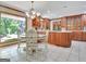 Charming kitchen features custom wood cabinetry, island, granite countertops, and large bright window with eating area at 115 Shoal Creek Dr, Sharpsburg, GA 30277