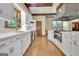 A spacious kitchen showcasing white cabinetry, stainless steel appliances, and unique wood flooring at 115 Shoal Creek Dr, Sharpsburg, GA 30277