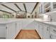 Galley-style kitchen with white cabinets and countertops open to the expansive living space at 115 Shoal Creek Dr, Sharpsburg, GA 30277