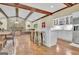 Spacious room featuring hardwood floors, wood beam ceilings, and a stone fireplace at 115 Shoal Creek Dr, Sharpsburg, GA 30277