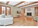 Living room with fireplace, hardwood flooring, backyard view, and exposed beams at 115 Shoal Creek Dr, Sharpsburg, GA 30277