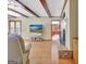Living room featuring hardwood flooring, fireplace, exposed beams, and access to backyard at 115 Shoal Creek Dr, Sharpsburg, GA 30277