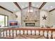 Living room showcases a stone fireplace, wood beams, and unique lighting fixture at 115 Shoal Creek Dr, Sharpsburg, GA 30277