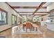 Spacious living area featuring wooden floors, beam ceilings, stone fireplace, and adjacent dining space at 115 Shoal Creek Dr, Sharpsburg, GA 30277
