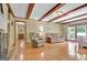 Comfortable living room with hardwood flooring, exposed beams, and backyard view at 115 Shoal Creek Dr, Sharpsburg, GA 30277