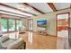 Living room with exposed beams, fireplace, backyard view, and access to kitchen at 115 Shoal Creek Dr, Sharpsburg, GA 30277