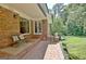 Charming brick patio features cozy seating, garden views, and leads to a meticulously maintained lawn at 115 Shoal Creek Dr, Sharpsburg, GA 30277
