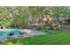 A refreshing pool is surrounded by manicured lawn, lounge chairs, and lush greenery at 115 Shoal Creek Dr, Sharpsburg, GA 30277