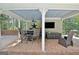 A charming pool house featuring an outdoor table and chairs, ceiling fan, and exterior TV, perfect for entertaining at 115 Shoal Creek Dr, Sharpsburg, GA 30277
