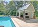 An inviting pool with a charming pool house and ample space for relaxing and entertaining outdoors at 115 Shoal Creek Dr, Sharpsburg, GA 30277