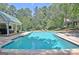 Backyard pool featuring a pool house, lounge chairs, and a landscaped yard, great for recreation and relaxation at 115 Shoal Creek Dr, Sharpsburg, GA 30277