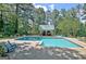 Backyard oasis featuring a sparkling pool, lush landscaping, and a pool house for outdoor relaxation and fun at 115 Shoal Creek Dr, Sharpsburg, GA 30277
