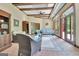 Sunroom featuring beamed ceilings, brick floors, and seating area with ample natural light at 115 Shoal Creek Dr, Sharpsburg, GA 30277