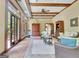 Sunroom features brick floors, beamed ceilings, and comfortable seating at 115 Shoal Creek Dr, Sharpsburg, GA 30277