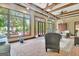 Brick-floored sunroom featuring exposed beams and multiple glass windows at 115 Shoal Creek Dr, Sharpsburg, GA 30277