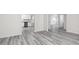 Open-concept living space featuring modern gray flooring, neutral walls, and a glimpse of the kitchen at 448 Prescott Way, Villa Rica, GA 30180