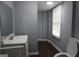 Bathroom featuring a sink, toilet, mirror, and window with horizontal blinds at 39 Mcferrin Cir, Riverdale, GA 30274