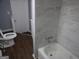 Bathroom with a white toilet and tub with tile surround, and luxury vinyl plank flooring at 39 Mcferrin Cir, Riverdale, GA 30274