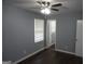 Bedroom with gray walls, light ceiling fan, dark wood flooring and two windows at 39 Mcferrin Cir, Riverdale, GA 30274
