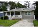 Inviting grey brick home with a covered front porch featuring white railing and a well-kept yard at 39 Mcferrin Cir, Riverdale, GA 30274