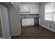 An eat-in kitchen with white cabinetry, dark hardware, gray counters, and wood flooring at 39 Mcferrin Cir, Riverdale, GA 30274