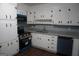 A kitchen showcasing white cabinets, dark hardware, gray countertops, wood flooring, and stainless appliances at 39 Mcferrin Cir, Riverdale, GA 30274