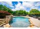 Backyard featuring a pristine pool with a stone waterfall and manicured landscaping at 713 Birkdale Blvd, Carrollton, GA 30116