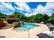 Backyard with a stunning pool, stone waterfall feature, and meticulously landscaped bushes and trees at 713 Birkdale Blvd, Carrollton, GA 30116