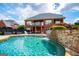 Backyard featuring a pristine pool with a stone waterfall and covered patio at 713 Birkdale Blvd, Carrollton, GA 30116