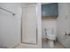 Bathroom featuring a glass-enclosed shower, a toilet, and grey upper cabinets for functional storage at 713 Birkdale Blvd, Carrollton, GA 30116