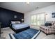 Comfortable bedroom featuring a navy accent wall, plantation shutters, and a sitting area at 713 Birkdale Blvd, Carrollton, GA 30116