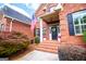 Inviting entryway with manicured landscaping, a brick porch, and an American flag at 713 Birkdale Blvd, Carrollton, GA 30116