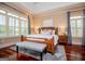 Well-lit main bedroom with tray ceilings, hardwood floors, and many windows with light-filtering blinds at 713 Birkdale Blvd, Carrollton, GA 30116